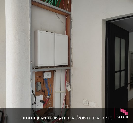 ארון חשמל פתוח עם חוטים וצינורות חשמל